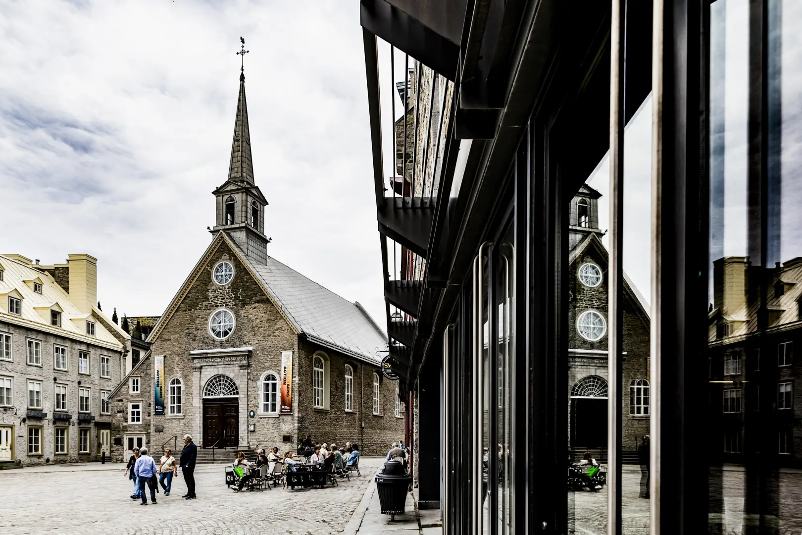 A photo of the Notre-Dame-des-Victoires Church located in Place Royale (market square) in Old Quebec City with reflections in the windows. Ein Foto der Notre-Dame-des-Victoires-Kirche auf dem Place Royale (Marktplatz) in der Altstadt von Québec mit Spiegelungen in den Fenstern.